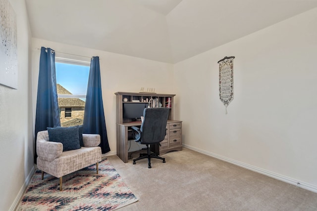 carpeted office space featuring lofted ceiling and baseboards