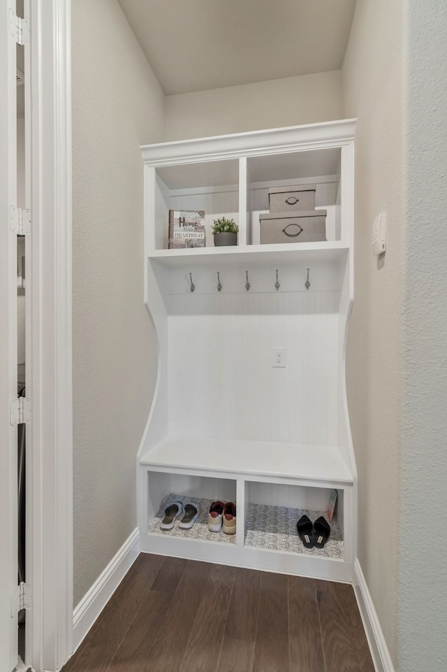 mudroom with dark wood finished floors and baseboards