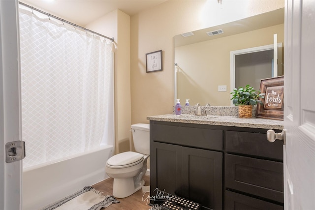 bathroom with shower / bath combo, visible vents, toilet, wood finished floors, and vanity