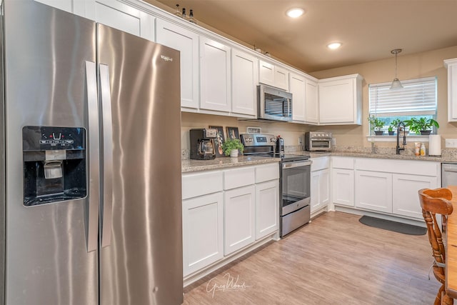 kitchen featuring recessed lighting, a sink, light wood-style floors, white cabinets, and appliances with stainless steel finishes