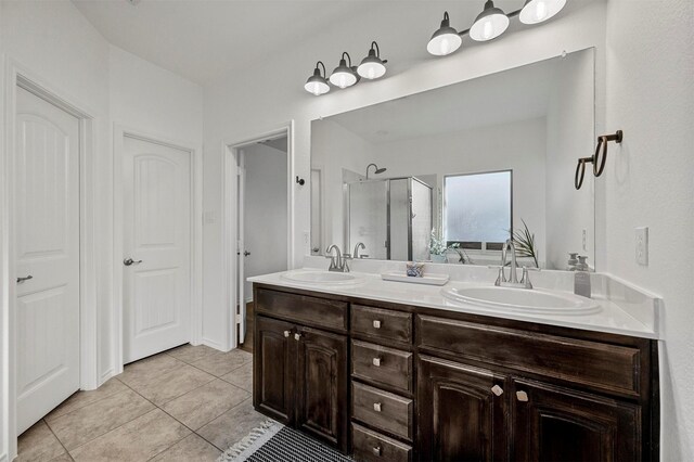 bathroom with a stall shower, tile patterned floors, a sink, and double vanity