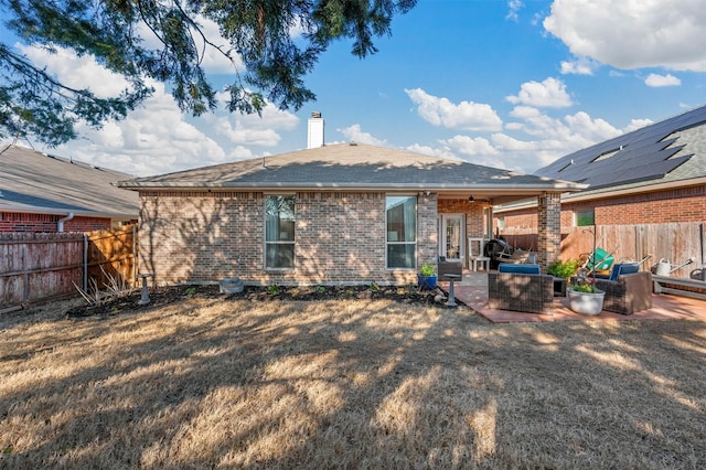 back of property featuring brick siding, a chimney, a patio area, and a fenced backyard