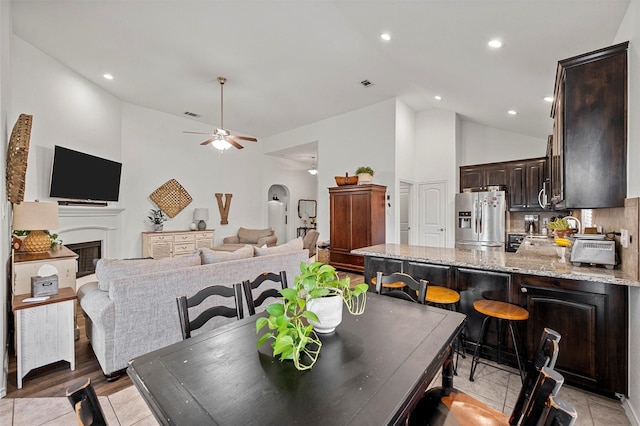 dining room with a fireplace, recessed lighting, visible vents, ceiling fan, and high vaulted ceiling