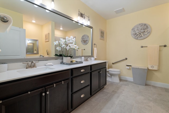 full bath featuring double vanity, toilet, baseboards, and a sink