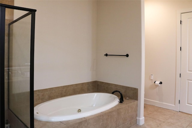 bathroom featuring tile patterned flooring, a shower stall, and a bath