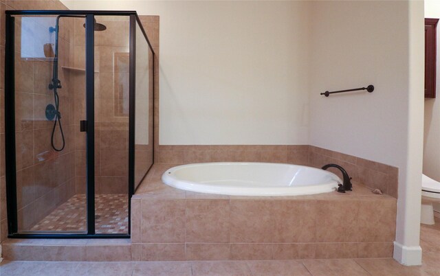 full bathroom featuring tile patterned flooring, a garden tub, a shower stall, and a spacious closet