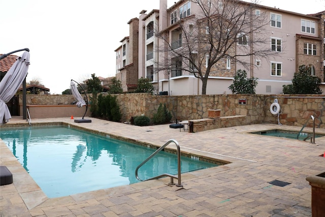 pool featuring a patio and a hot tub