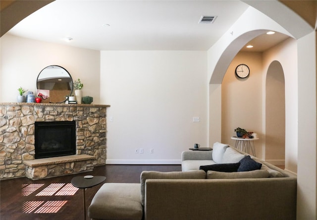 living area featuring recessed lighting, a fireplace, wood finished floors, visible vents, and baseboards