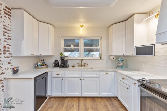 kitchen with electric range, light wood-style flooring, decorative backsplash, white cabinets, and dishwasher