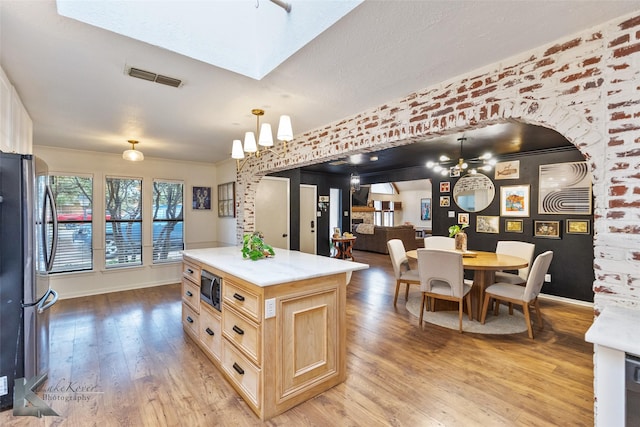 1258 Canterbury Dr, Abilene, TX 79602 - kitchen with appliances with stainless steel finishes, light brown cabinetry, light countertops, and light wood finished floors