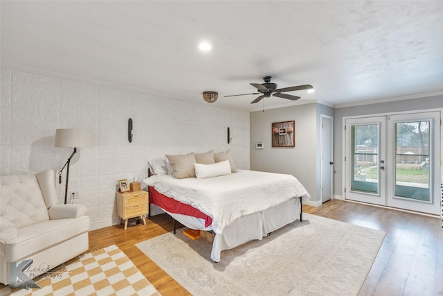 bedroom with access to exterior, ornamental molding, light wood-style flooring, and baseboards