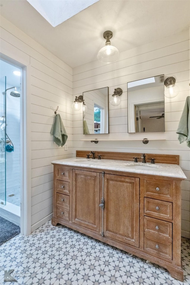 full bathroom with wood walls, a sink, tile patterned floors, double vanity, and walk in shower