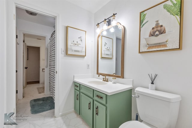 bathroom featuring toilet, baseboards, and vanity