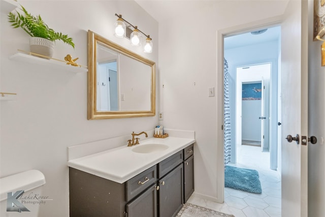 bathroom featuring toilet, tile patterned flooring, and vanity