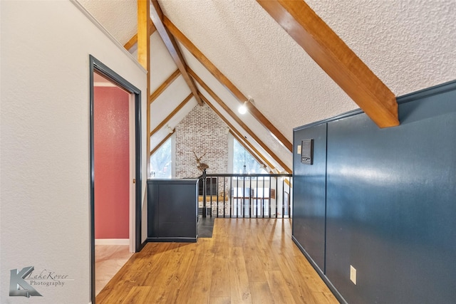 bonus room featuring a textured ceiling, wood finished floors, and vaulted ceiling with beams