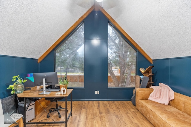 office area featuring vaulted ceiling, a textured ceiling, and wood finished floors