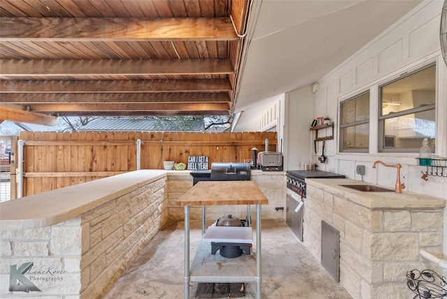 view of patio featuring a sink, exterior kitchen, grilling area, and fence