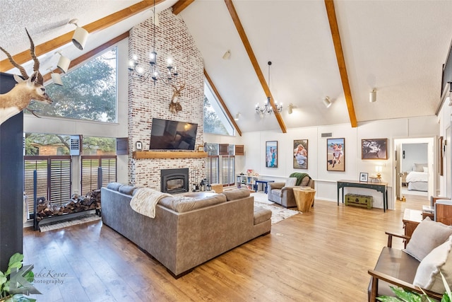 living room with high vaulted ceiling, beamed ceiling, wood finished floors, and an inviting chandelier