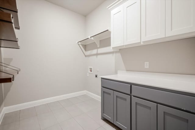 washroom with light tile patterned flooring, hookup for an electric dryer, washer hookup, baseboards, and cabinet space