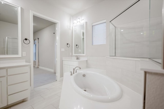 bathroom featuring walk in shower, a bath, and vanity