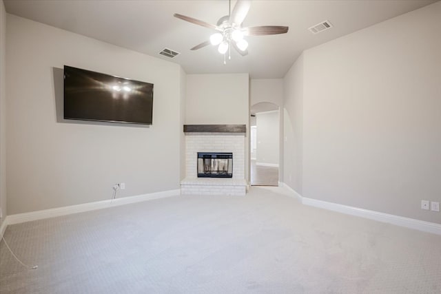 unfurnished living room with baseboards, a fireplace, and visible vents