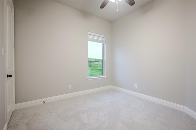 unfurnished room featuring baseboards, a ceiling fan, and light colored carpet