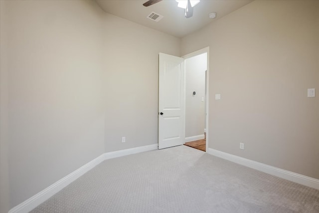 unfurnished room featuring baseboards, ceiling fan, visible vents, and light colored carpet