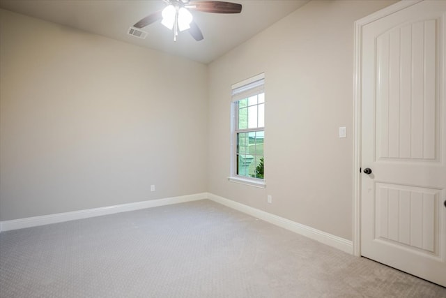 spare room with light carpet, baseboards, visible vents, and ceiling fan