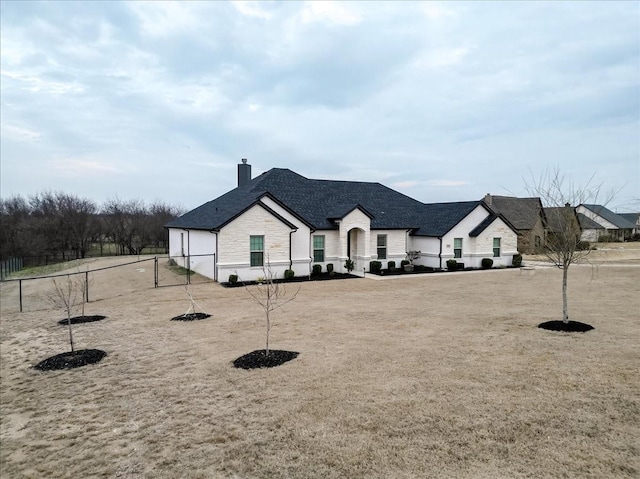 view of front of property featuring stone siding, a chimney, and fence