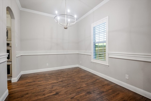 spare room with baseboards, dark wood-type flooring, an inviting chandelier, and crown molding