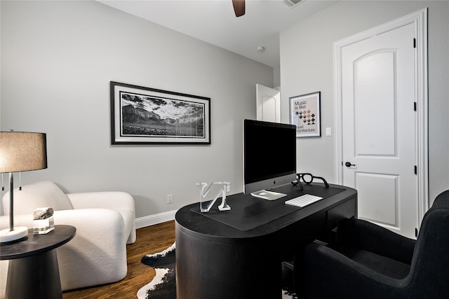 office area with dark wood-type flooring, visible vents, ceiling fan, and baseboards