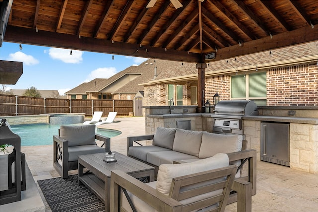 view of patio with an outdoor kitchen, a fenced backyard, a gazebo, an outdoor living space, and a sink