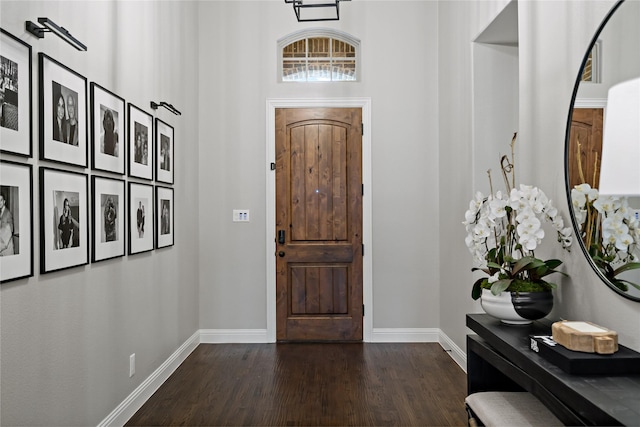 foyer featuring dark wood-type flooring and baseboards