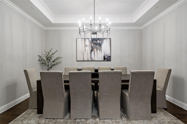 dining space with wood finished floors, a raised ceiling, and baseboards