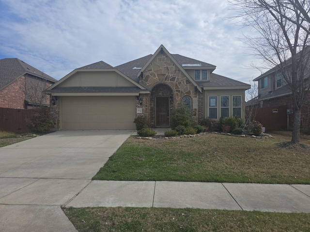 view of front of house featuring fence, a garage, stone siding, driveway, and a front lawn