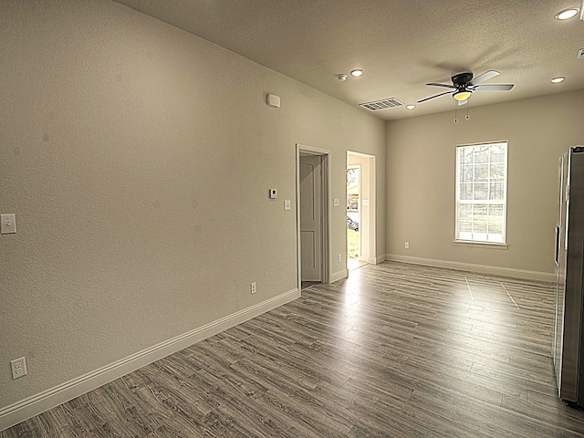 spare room with dark wood-style floors, ceiling fan, and baseboards