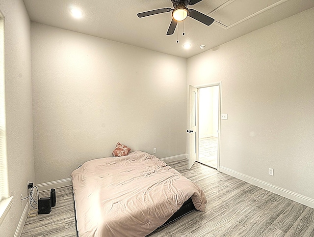 bedroom featuring light wood finished floors and baseboards