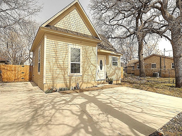 view of front of property with entry steps, a patio area, fence, and central AC