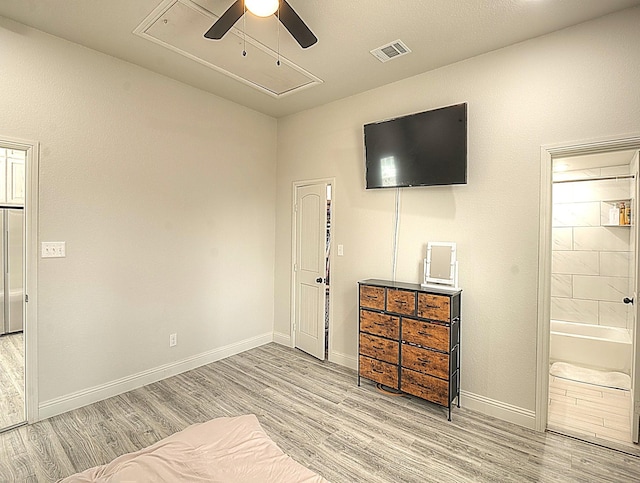 bedroom featuring visible vents, baseboards, light wood-type flooring, stainless steel built in refrigerator, and attic access