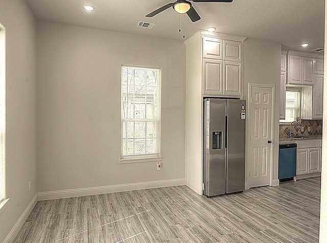 kitchen featuring baseboards, visible vents, dishwashing machine, light wood-style floors, and stainless steel refrigerator with ice dispenser