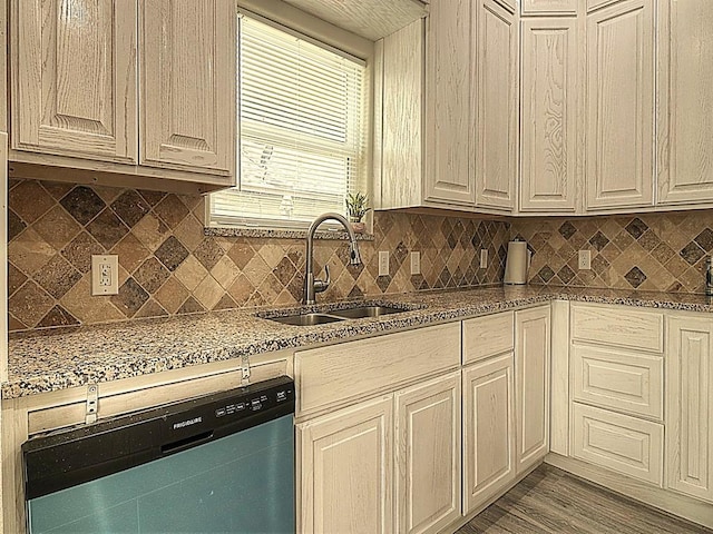 kitchen with dishwashing machine, backsplash, a sink, and wood finished floors