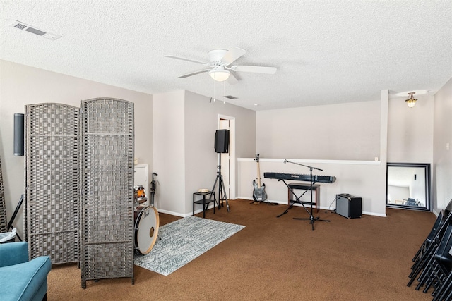 rec room featuring a textured ceiling, ceiling fan, visible vents, baseboards, and carpet