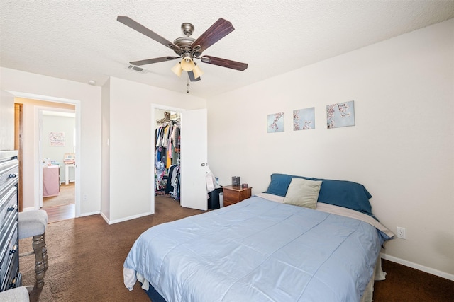 carpeted bedroom featuring visible vents, ceiling fan, a spacious closet, a textured ceiling, and a closet