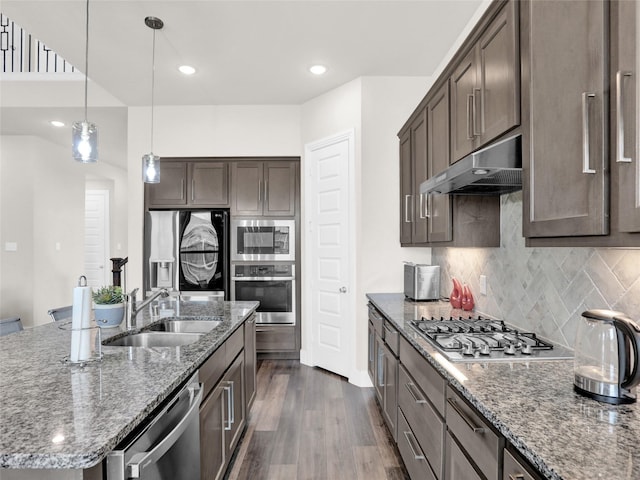 kitchen featuring dark wood-style floors, appliances with stainless steel finishes, dark brown cabinets, under cabinet range hood, and a sink