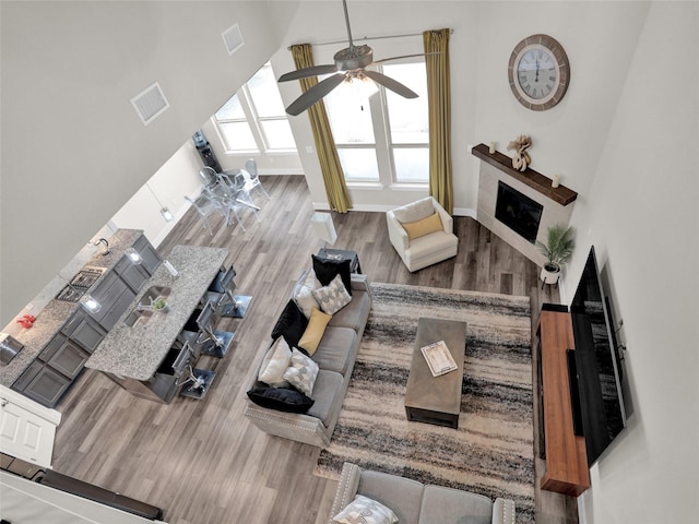 living room featuring visible vents, a fireplace, and wood finished floors