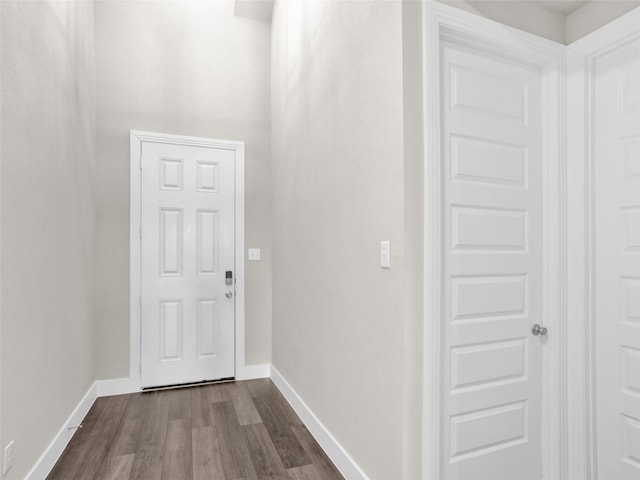 interior space featuring baseboards and dark wood-type flooring