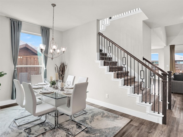 dining room featuring stairs, a chandelier, wood finished floors, and baseboards