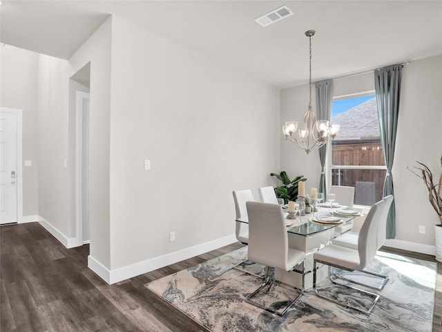 dining space featuring a chandelier, dark wood-type flooring, visible vents, and baseboards