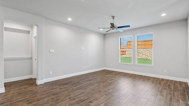 spare room with dark wood-type flooring, recessed lighting, baseboards, and a ceiling fan