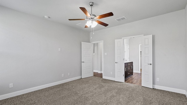 unfurnished bedroom with visible vents, dark carpet, baseboards, and ceiling fan